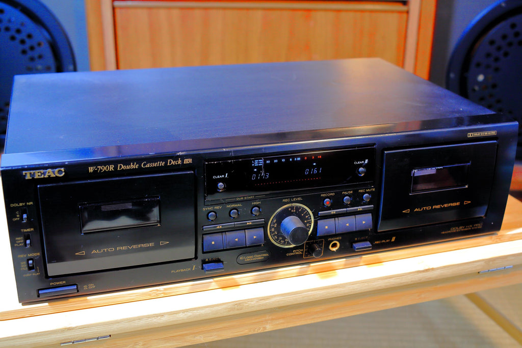 May include: Black TEAC W-790R Double Cassette Deck. The stereo features two cassette decks, a digital display, and various control buttons. The unit is on a light-colored wooden surface.